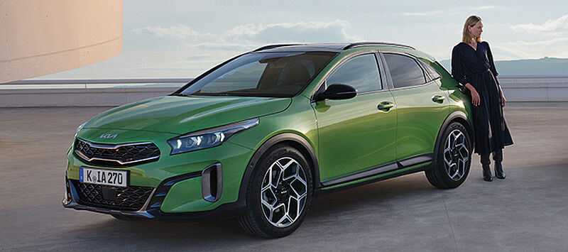 Parkierter Kia XCeed grün mit Person