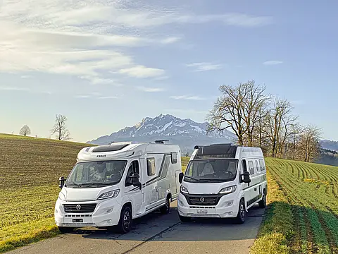 2 weisse Wohnmobile auf dem Land im Kanton Luzern.