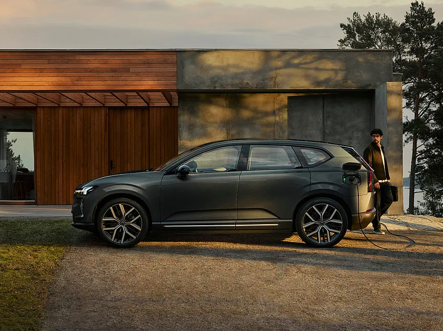Volvo EX60 wird vor einem Haus aufgeladen.