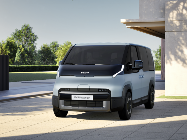 Kia PV5 Passenger hellblau draussen vor einem Gebäude