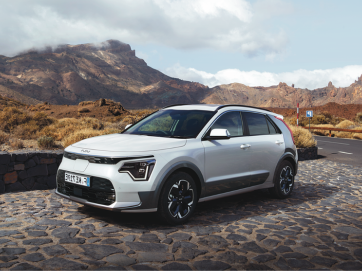 Kia Niro auf Pflasterstrasse mit Berg im Hintergrund