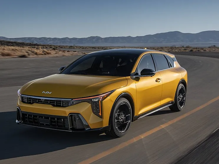 Kia K4 Hatchback Gold in Wüste fahren auf einer Strasse