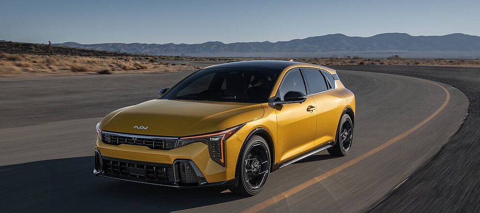 Kia K4 Hatchback Gold in Wüste fahren auf einer Strasse